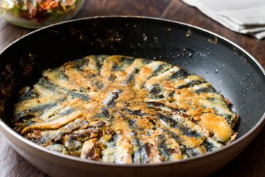 Taze kızarmış sardalye salata ahşap yüzeyi ile tavada.