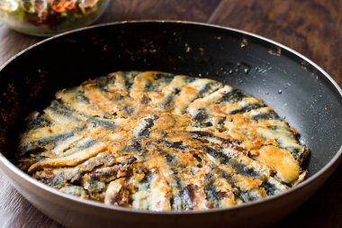 Taze kızarmış sardalye salata ahşap yüzeyi ile tavada.