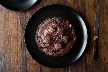 Çikolatalı profiterol pasta siyah plaka üzerinde