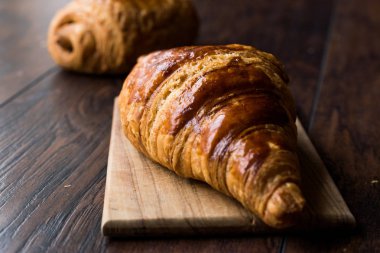Ahşap yüzey üzerinde taze pişmiş kruvasan.