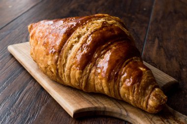 Ahşap yüzey üzerinde taze pişmiş kruvasan.
