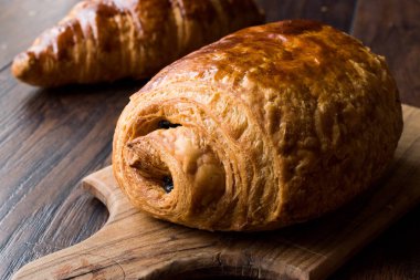 Ahşap yüzey üzerinde taze pişmiş çikolata kruvasan.