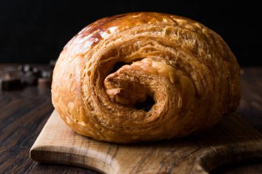 Ahşap yüzey üzerinde taze pişmiş çikolata kruvasan.