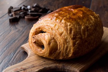 Ahşap yüzey üzerinde taze pişmiş çikolata kruvasan.