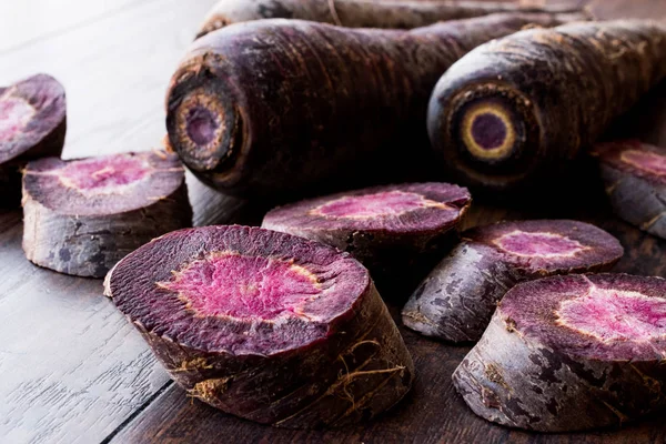 Zanahorias púrpuras en la superficie de madera oscura . — Foto de Stock