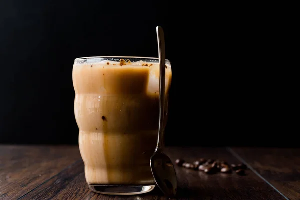 Caffè freddo istantaneo con latte, ghiaccio, cucchiaio e chicchi di caffè . — Foto Stock