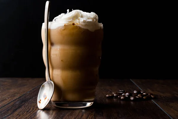 Café frío con crema batida y leche, cuchara y granos de café —  Fotos de Stock