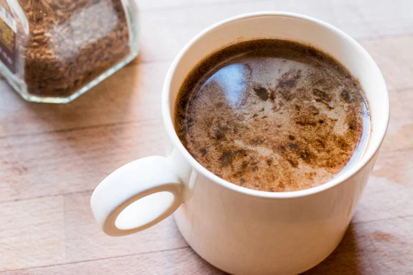 Моментальный гранулированный кофе порошок смешанный с горячей водой . — стоковое фото