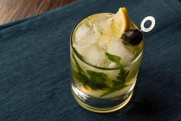 Dillionaire Cocktail with Dill, Gin, Parsley, lemon, Olive and Crushed Ice. — Stock Photo, Image