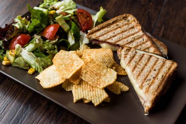 Türk tost ya da sandviç / üçgen Club sandviç eritilmiş peynir, jambon ve cips ve salata ile servis.