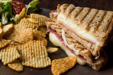 Türk tost ya da sandviç / üçgen Club sandviç eritilmiş peynir, jambon ve cips ve salata ile servis.