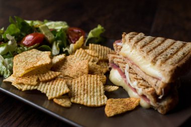 Türk tost ya da sandviç / üçgen Club sandviç eritilmiş peynir, jambon ve cips ve salata ile servis.