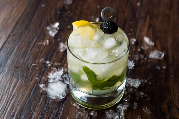 Whiskey-Cocktail mit Minzblättern, Zitrone, Oliven und Crushed Ice. — Stockfoto