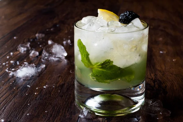 Whiskey-Cocktail mit Minzblättern, Zitrone, Oliven und Crushed Ice. — Stockfoto