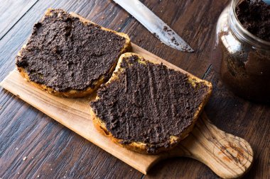 Ekmek bıçağı ve kavanoz ile üzerinde Siyah Zeytin Tapenade