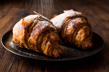 Kruvasan ile pudra şekeri serpilir