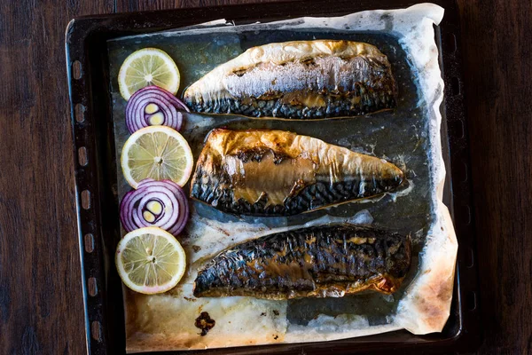 Pescado de caballa con cebolla y limones en bandeja para hornear . —  Fotos de Stock