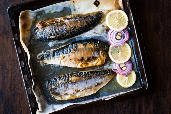 Pescado de caballa con cebolla y limones en bandeja para hornear . —  Fotos de Stock