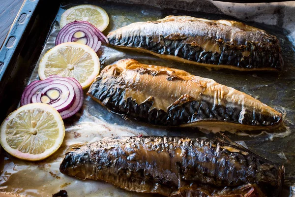 Pescado de caballa con cebolla y limones en bandeja para hornear . —  Fotos de Stock