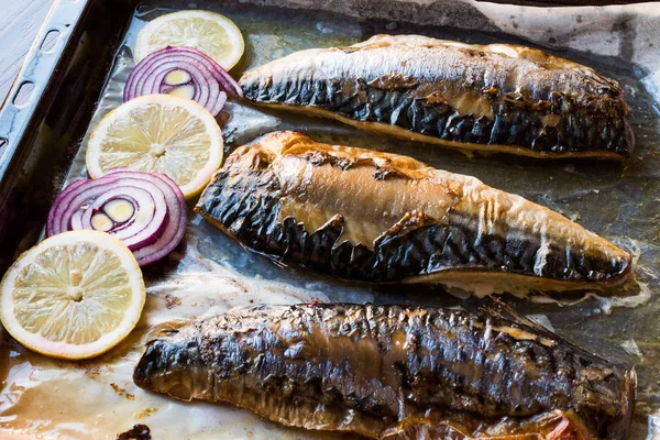 Pescado de caballa con cebolla y limones en bandeja para hornear . —  Fotos de Stock