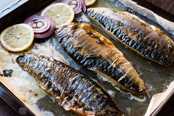 Makreel vissen met uien en citroenen in baksel lade. — Stockfoto