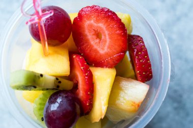 Çilek, kivi, Mango ve plastik kap içinde üzüm meyve salatası.