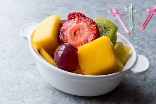 Mini salada de frutas com morango, Kiwi, manga e uva em taça de cerâmica branca . — Fotografia de Stock