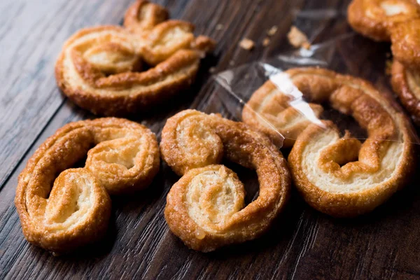 Palmier soubory cookie v černém plátu na dřevěný povrch. — Stock fotografie