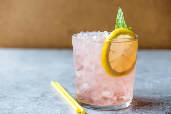 Розовый коктейль со льдом, мятой и лимоном — стоковое фото