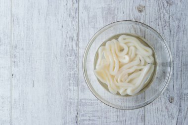 Suda ıslatın ve cam kase çiğ kalamar kalamar halkaları.