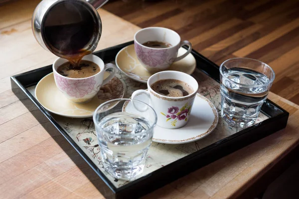 Наливание турецкий кофе подается с водой в лоток . — стоковое фото