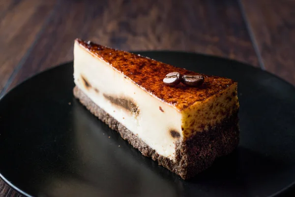 Kaffe Cheesecake på svart tallrik med mörk trä yta. — Stockfoto