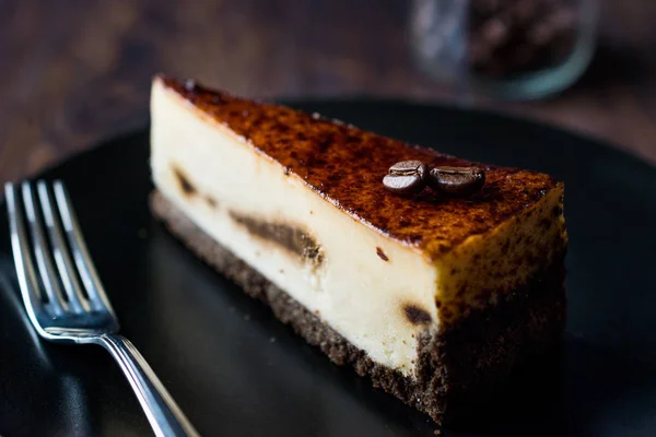 Kaffe Cheesecake på svart tallrik med mörk trä yta. — Stockfoto