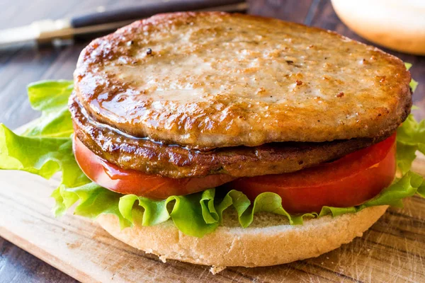 Hamburguesa doble abierta con carne de pavo, lechuga y tomates en superficie de madera . — Foto de Stock