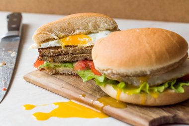 Yumurta, domates ve marul Hamburger ahşap yüzeyde ikiye ayırmak. 