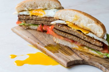 Yumurta, domates ve marul Hamburger ahşap yüzeyde ikiye ayırmak. 