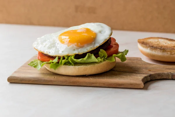 Otwórz Hamburger z jaj, sałata i pomidory na powierzchni drewnianych. — Zdjęcie stockowe