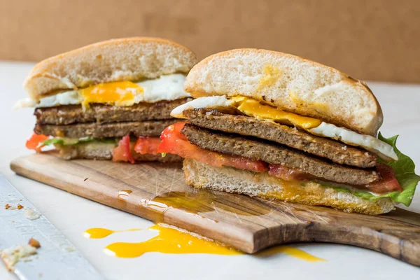 Połowę Wytnij Hamburger z jajek, pomidorów i sałaty na powierzchni drewnianych. — Zdjęcie stockowe