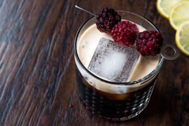 Black / Dark Beer Cocktail with Blackberries and Ice on Wooden Surface. clipart