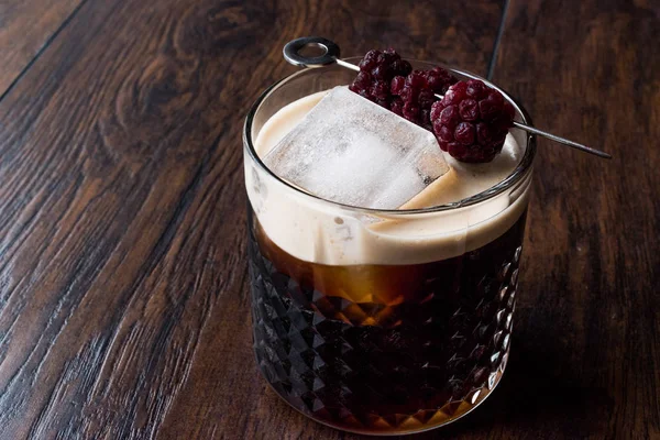 Cocktail de cerveja preta / escura com amoras e gelo na superfície de madeira . — Fotografia de Stock