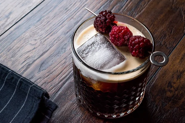 Cocktail de cerveja preta / escura com amoras e gelo na superfície de madeira . — Fotografia de Stock