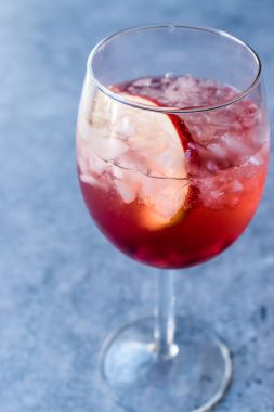 Pembe allık şarap kokteyl nar taneleri, elma dilim ve kırılmış buz ile yükseldi.