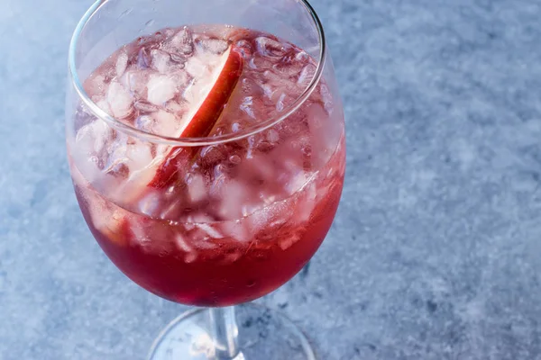 Rosa Rouge Wein-Cocktail mit Granatapfelkernen, Apfelscheibe und zerstoßenem Eis. — Stockfoto
