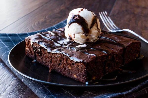 Brownie al cioccolato con gelato e polvere di nocciole . Fotografia Stock