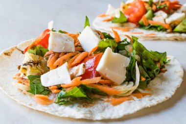 Ev yapımı vejetaryen Tostadas salata, peynir ve rendelenmiş havuç dilimleri ile.