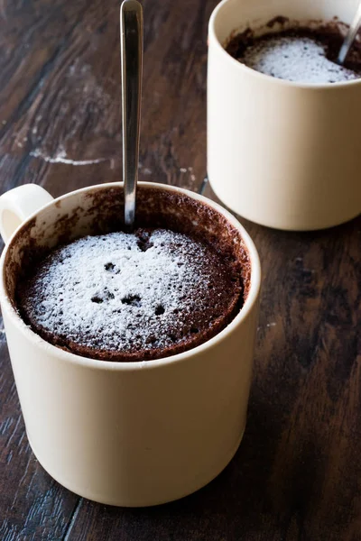 Pastel de taza de chocolate Brownie microondas con azúcar en polvo en la superficie de madera oscura . —  Fotos de Stock