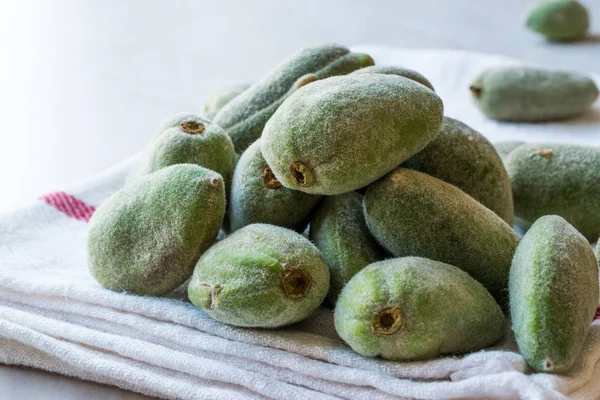 Stack of Fresh Green Almond Nut Fruits on tablecloth.