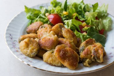 Kızarmış gevrek midye salata ile servis.