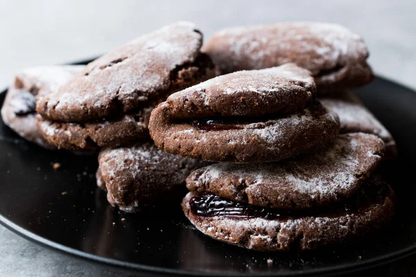 Заполненные желе шоколадные печенья с сахарной пудрой и вишневым джемом . — стоковое фото