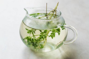 Cam çaydanlık yaprakları ile dumanı tüten bitkisel çay 